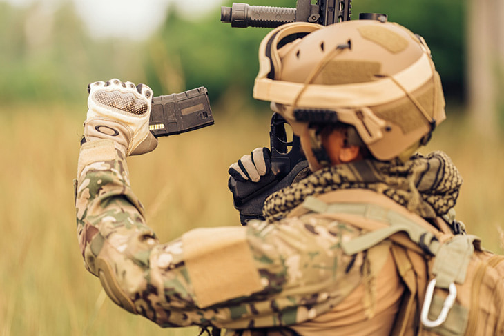 A soldier reloading a weapon during a training exercise.