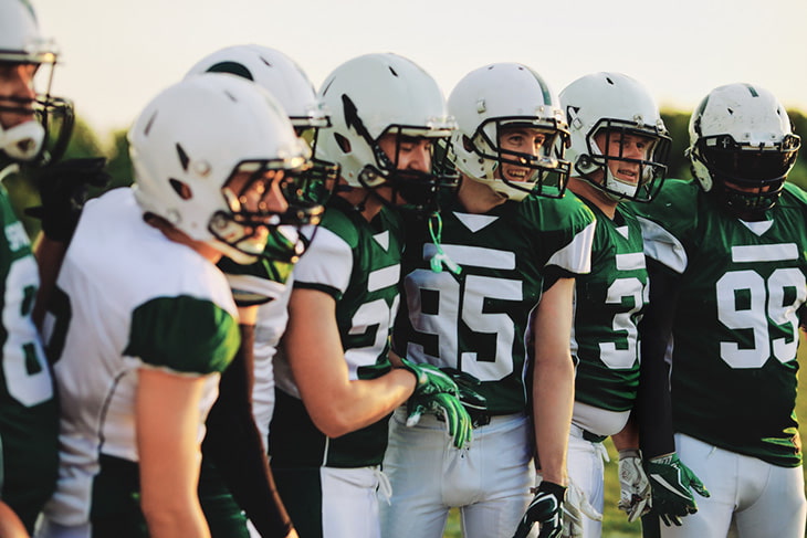 A football team huddling at a practice.