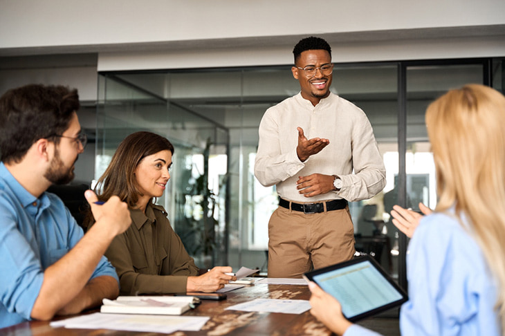 A small group meeting of professionals in an office space.