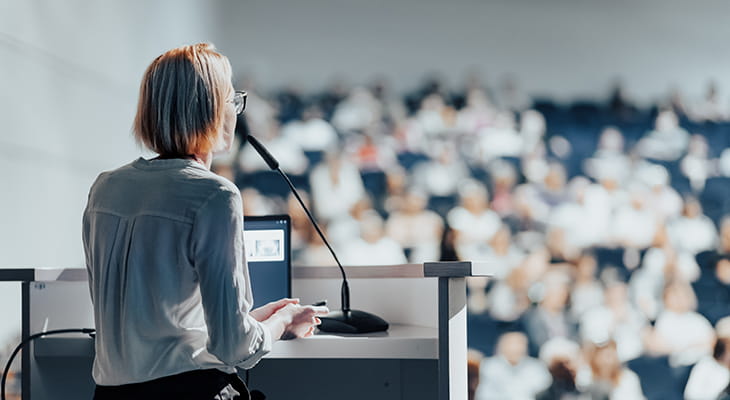 A woman gives a presentation at a conference