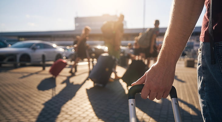 Travels roll luggage and suitcases in an airport parking lot