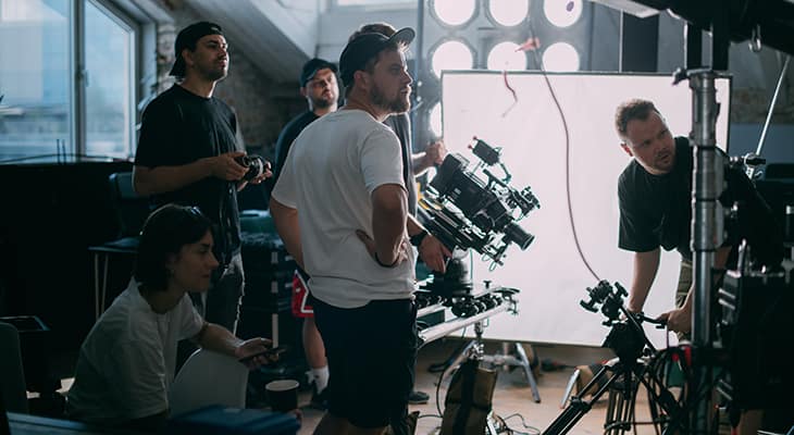 Crew members set up equipment on a film set