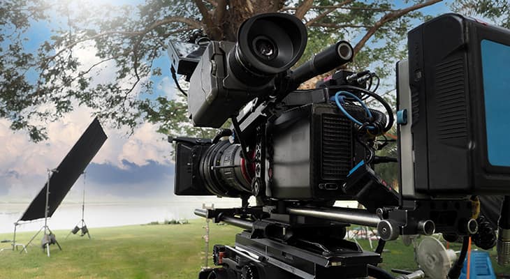 A professional camera films at a park location