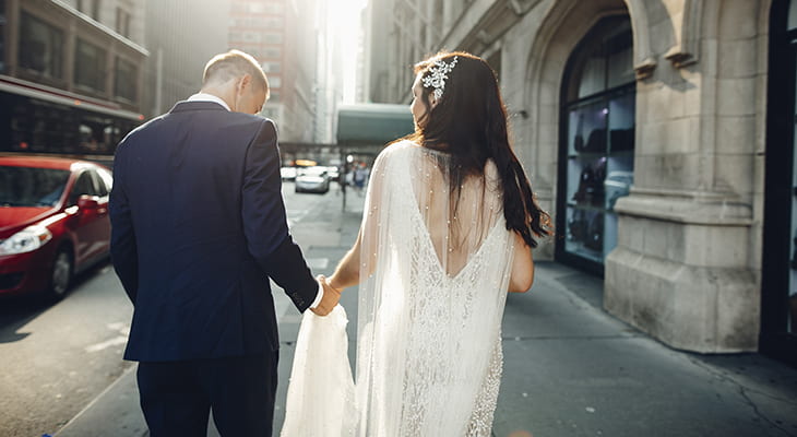 Bride and groom walk through Chicago streets holding hands