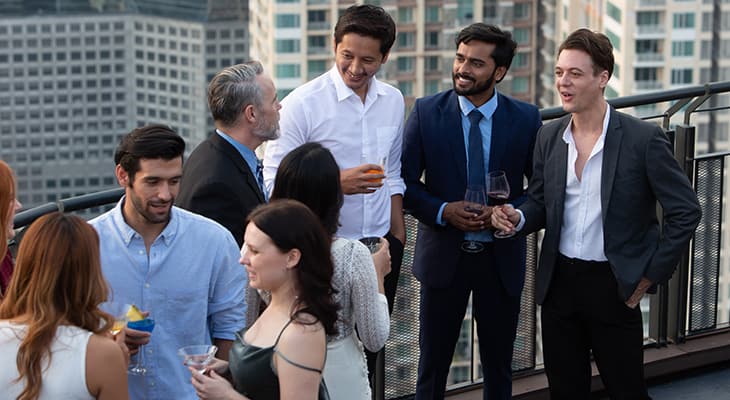 A rooftop balcony full of party-goers