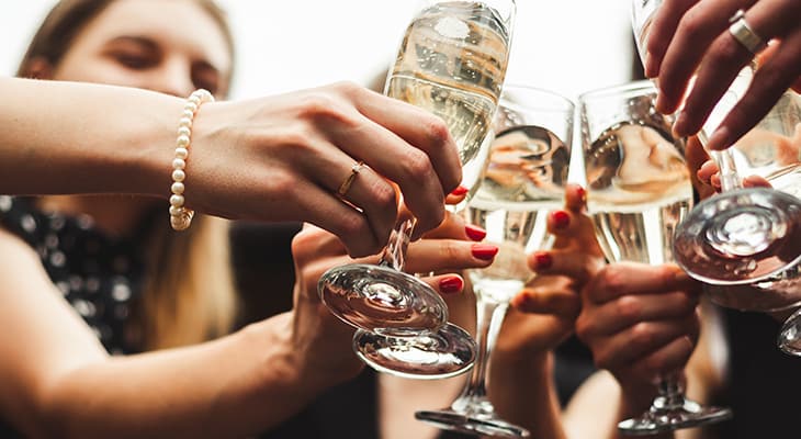 Attendees toast glasses of wine at a party