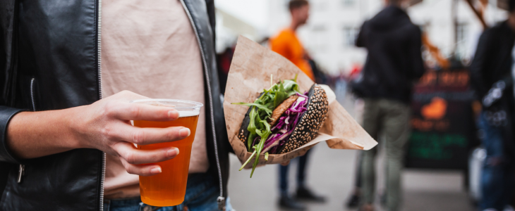 a woman with wine and a burger at a food festival